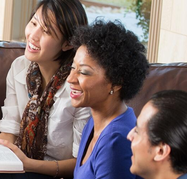 People gathered on a couch laughing