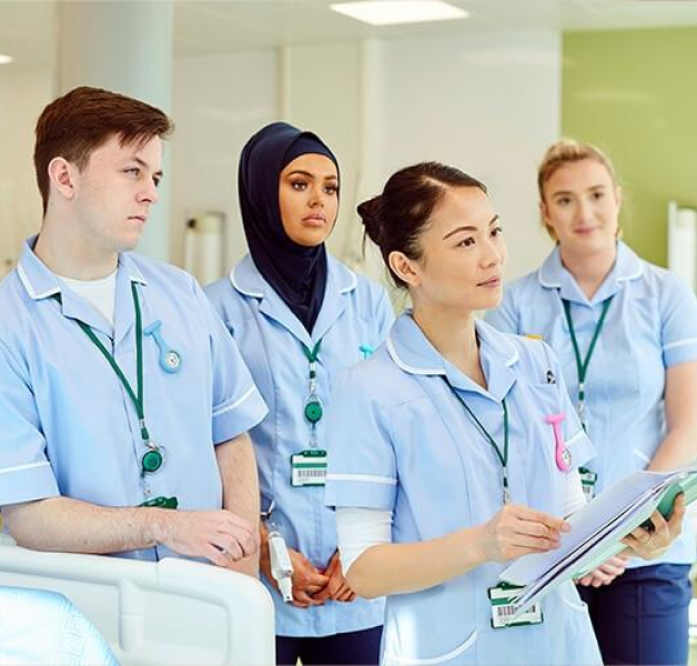 Healthcare workers in a hospital gathered to listen to someone speak