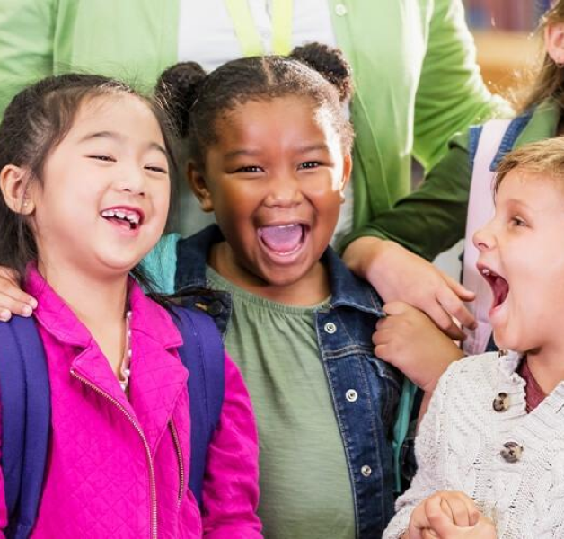 Young kids with backpacks smiling and laughing